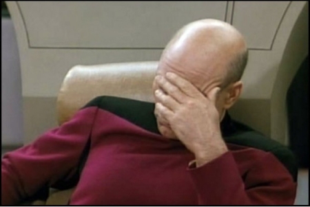 Seated on the bridge of the Enterprise, Captain Picard does a pained face-palm